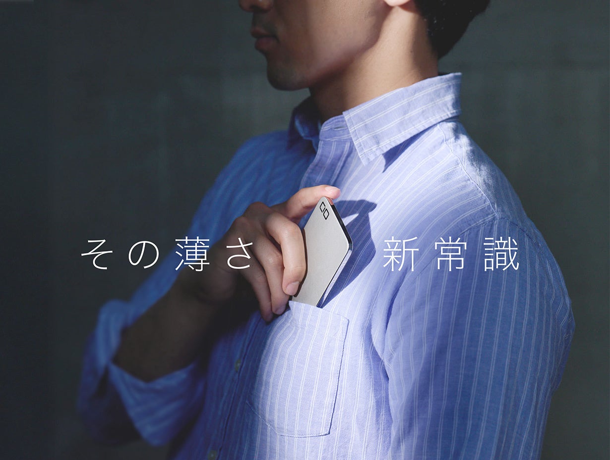 男性がシャツのポケットから薄いカード型のデバイスを取り出している
