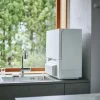 キッチンのシンク横に設置された白い卓上型食器洗い乾燥機