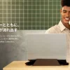 コーヒーを飲みながらノートPCとスマホスタンドを使用する男性