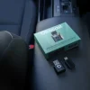 車内のセンターコンソールに置かれた製品パッケージと本体、USBアダプター