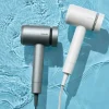 メタリックグレーとパールホワイトの2色のヘアドライヤーが水面に並んでいる様子。