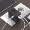 海外用変換プラグをコンセントに差し込み、スマホとPCを同時に充電している様子