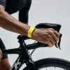 自転車に乗る人の手首に装着されたイエローのWHOOP 5.0用ケース