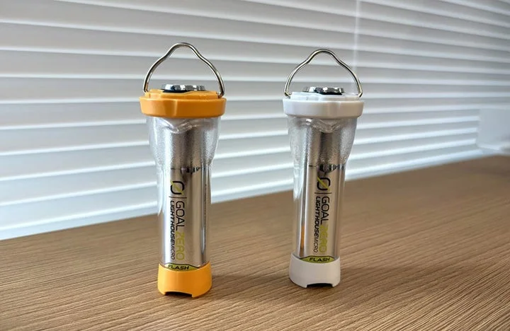 木目調のテーブルに置かれたオレンジとホワイトのLEDランタン