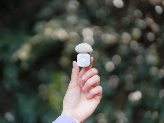 ウィンドスクリーンを装着したDJI Mic Mini 2Sを指でつまんでいる様子