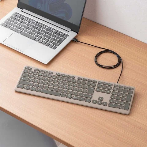 ノートパソコンにUSBケーブルで接続されたワイヤレスキーボード