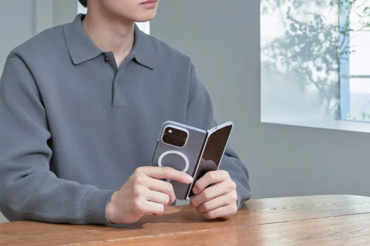 磁石を内蔵したスマホケースを装着した端末を持つ人物