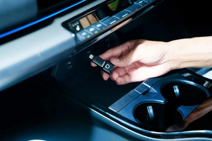 車のUSBポートにOttocast Mini Auraを差し込もうとしている手元