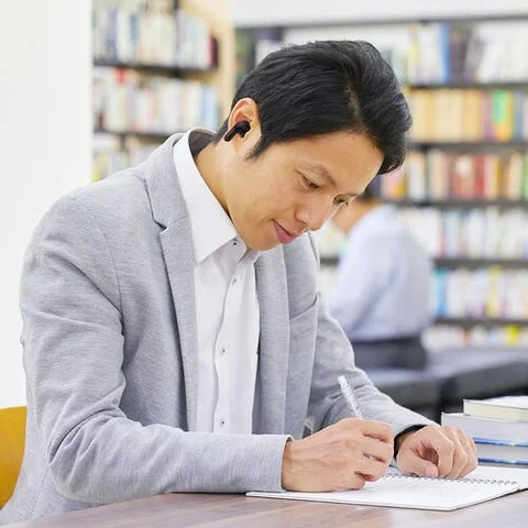 オフィスでイヤホンを装着して作業する男性