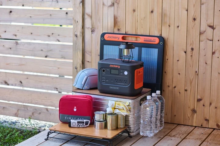 Jackery ポータブル電源 1500 Newと防災グッズ、水が置かれている様子。
