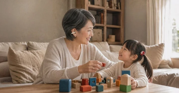 女性が子供と遊びながらイヤーカフ型集音器を装着している様子