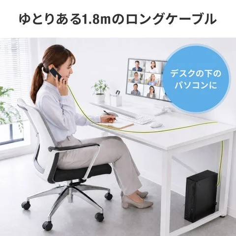 ロングケーブルでデスク下のPCに接続し通話する女性