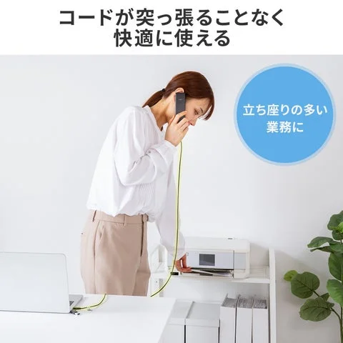 立ち上がってプリンタ付近で通話する女性