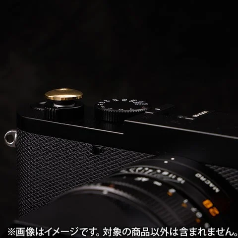 カメラに装着された真鍮色の小丸ソフトレリーズボタン