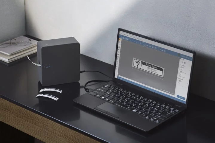 ノートPCと接続されたテプラPRO MARK SR-MK2と作成されたラベル
