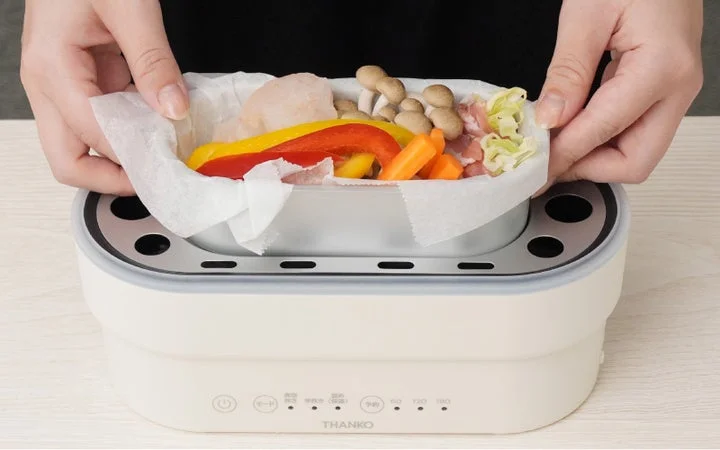 炊飯器のおかずトレイに食材をセットする様子