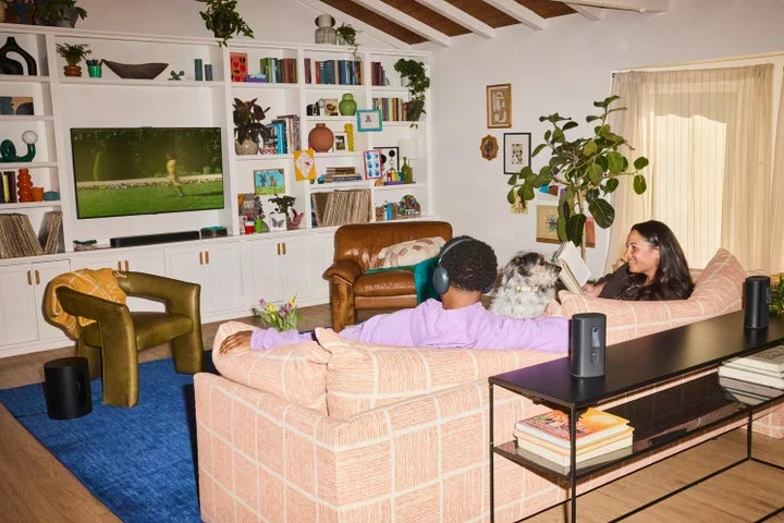 リビングでSonos Ace Ultraを装着してくつろぐ男性と、その横で読書をする女性の様子