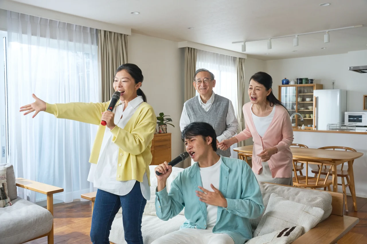 リビングでマイクを持って歌う家族の姿