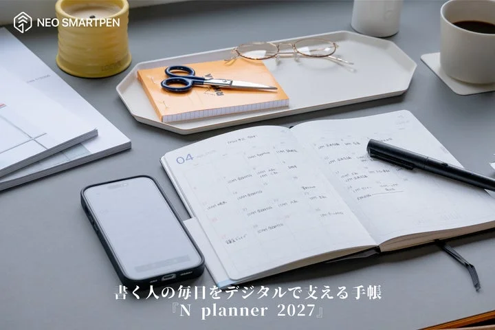 デスク上の手帳とスマートフォン、筆記具などの利用シーン
