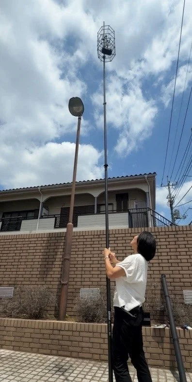 たおれん棒（鳥獣害対策タイプ）を一人が屋外で直立させている様子