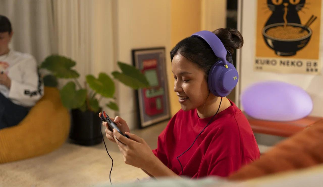JBL Quantum 120パープルを装着し、ゲーム機を操作する利用シーン