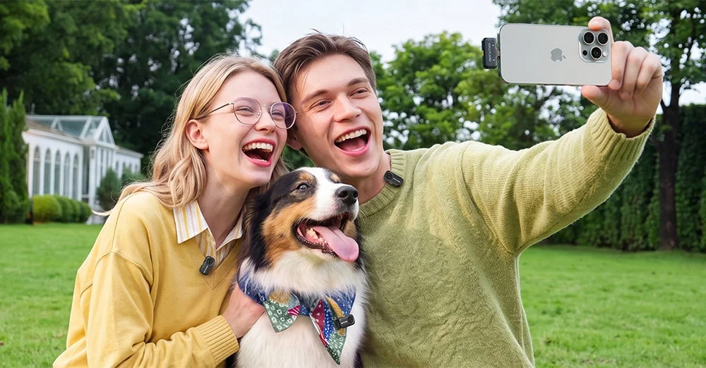 Lark A2の送信機を装着し、スマートフォンで撮影する人物と犬