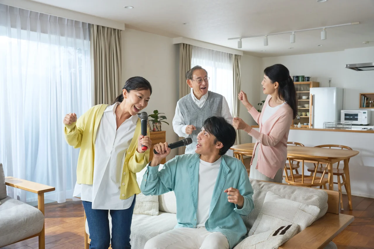 KARA×KARAで家族がリビングでマイクを持って歌う様子