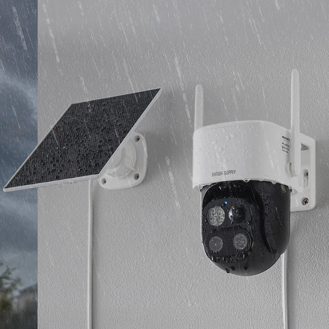 400-SSA014の防犯カメラとソーラーパネルを雨の中で設置した様子
