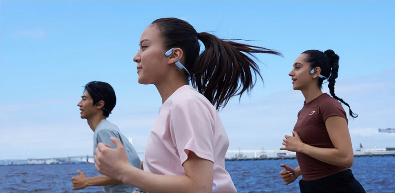 OpenRun Air 2を装着して海沿いを走る人々の様子