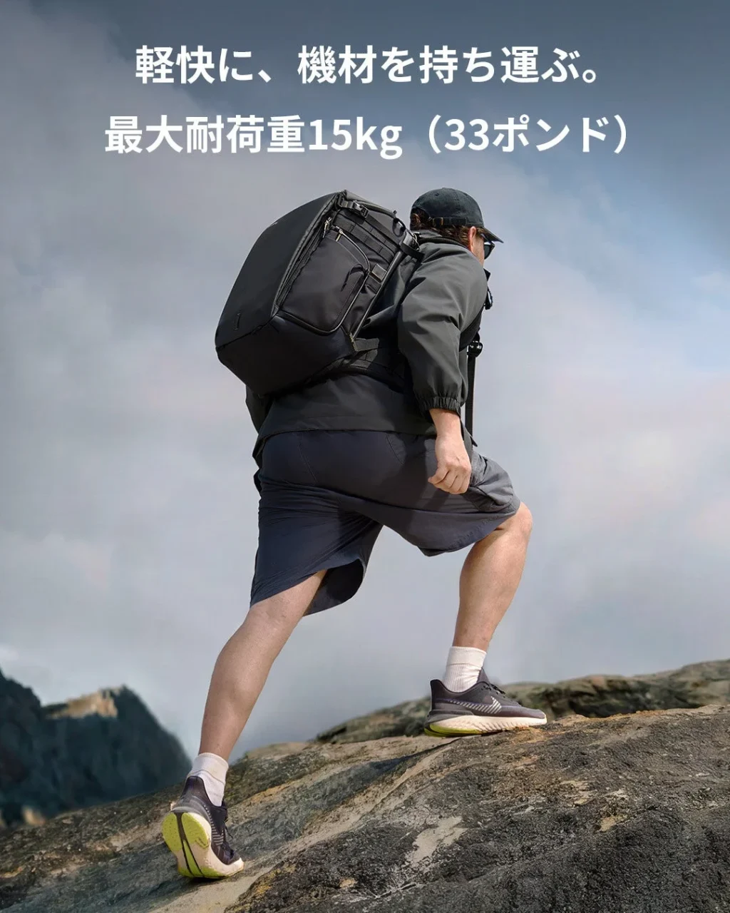 Outra 25 アウトドアカメラバッグを背負い岩場を歩く人物