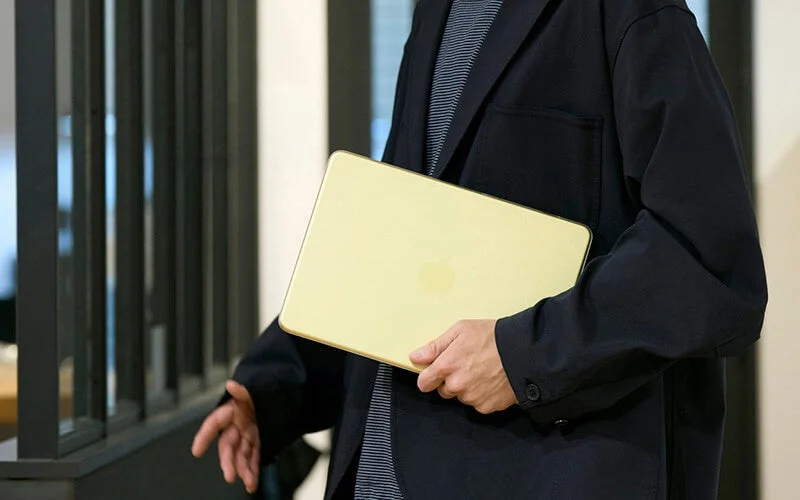 MacBook Neo専用ハードシェルカバー装着のMacBook Neoを人物が抱える様子