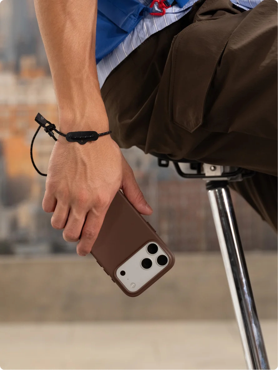 MOFT MOVAS™レザーケースを装着したiPhoneを手に持ち、手首にストラップを付けた利用シーン