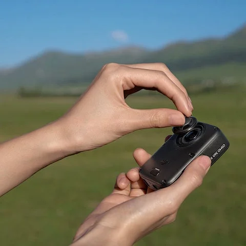 手でDJI Osmo 360 IIのレンズを交換している様子