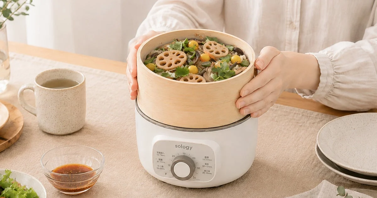 sology電気蒸し器に竹せいろを載せ、野菜料理を蒸す様子