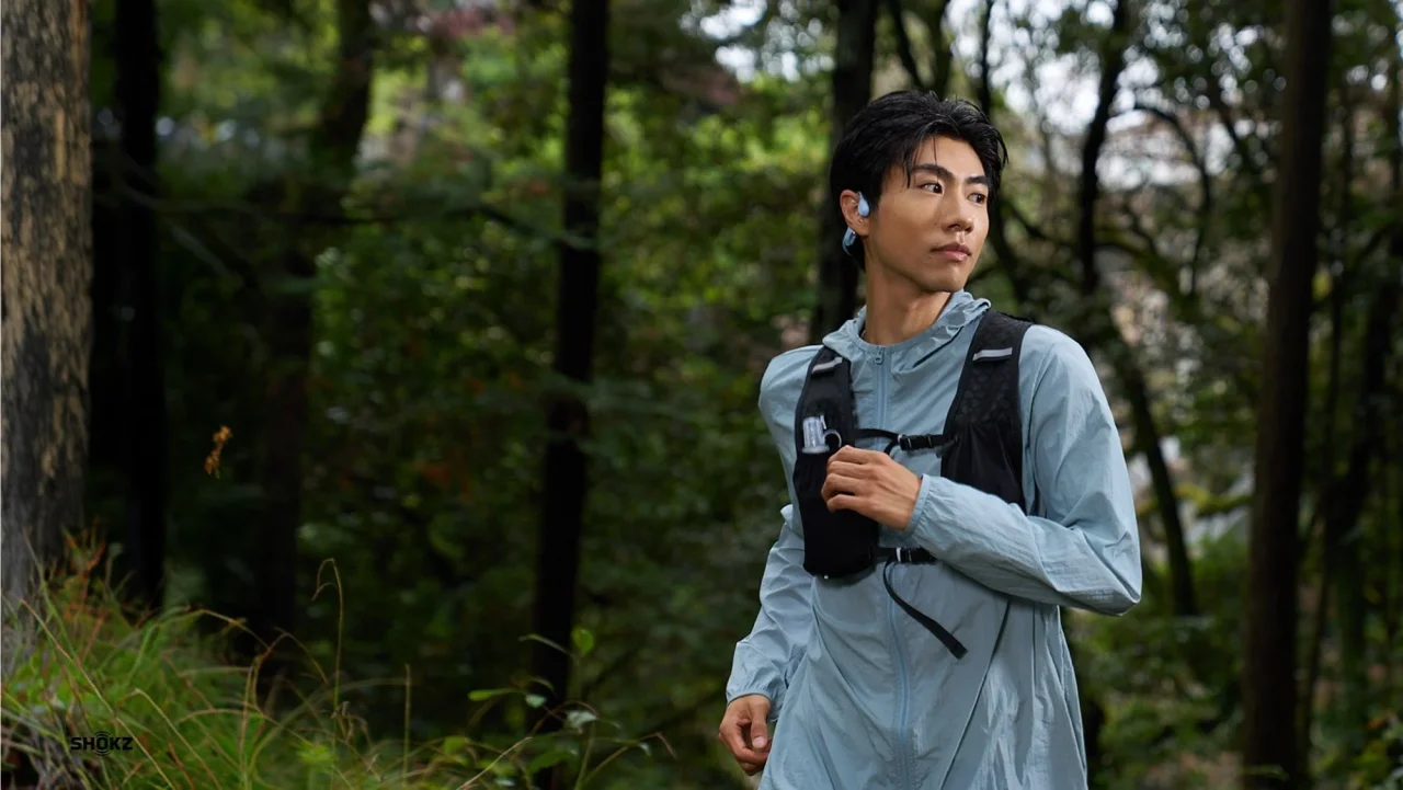 OpenRun Air 2を装着した男性が森の中でランニングする様子