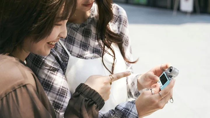 セルフィーミニカメラで撮影した写真を確認する二人組の女性