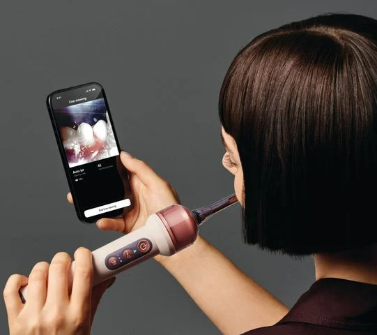 スマートフォンで口腔内のライブ映像を確認しながら歯磨きする様子