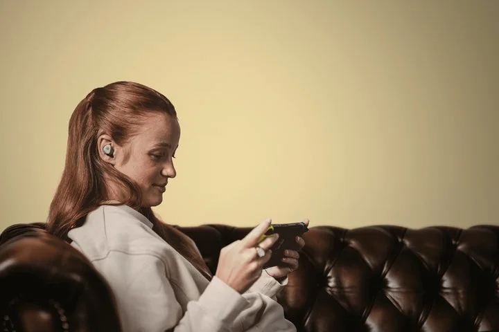 Arctis GameBudsを装着してゲームをする女性