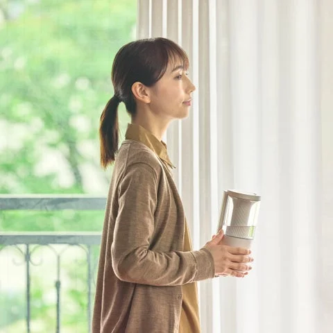 女性が片手で加湿器を持ち運んでいる様子