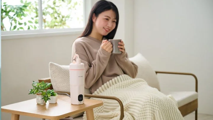 リビングでポータブルケトルを使い、くつろぐ女性