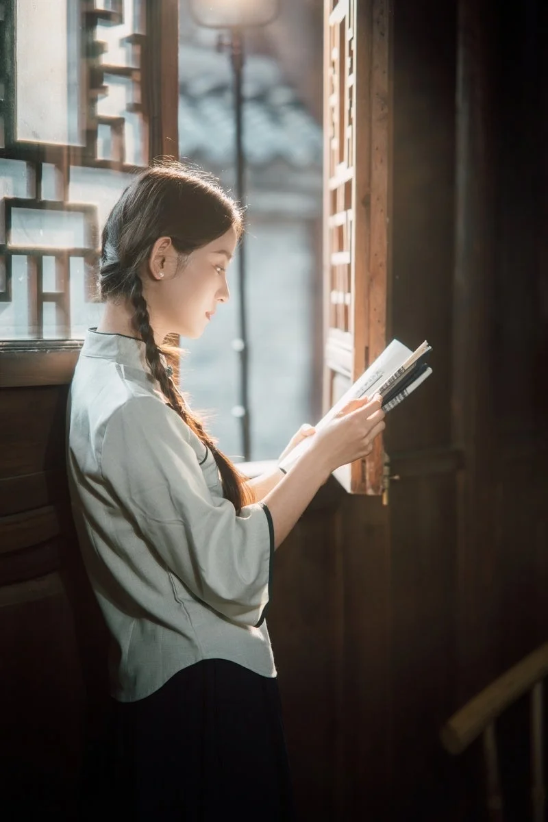 Neo AF 85mm f/1.8のサンプルフォト。窓辺で本を読む女性のポートレート