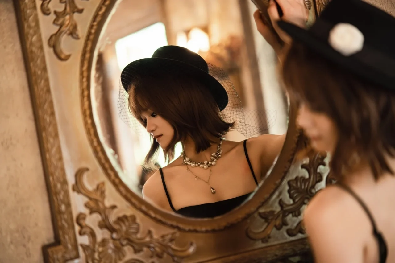 Neo AF 85mm f/1.8のサンプルフォト。鏡に映る黒い帽子の女性