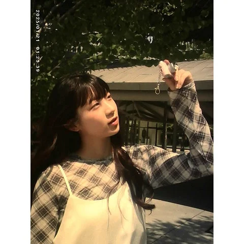 セルフィーミニカメラをかざして撮影する女性