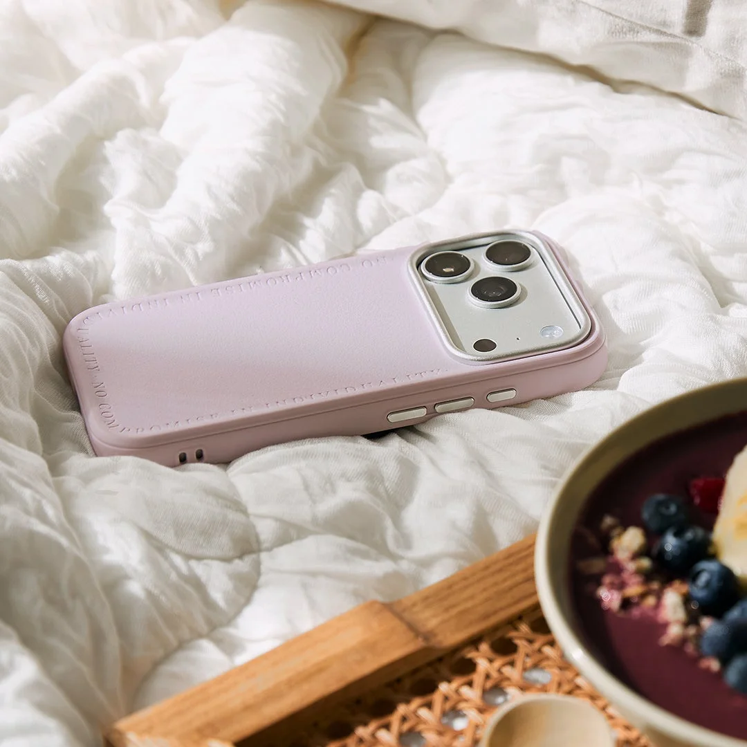 Sereluの淡いピンクのスマホケース。白い布の上に置かれ、カメラ部分にシルバーのフレームが見える。