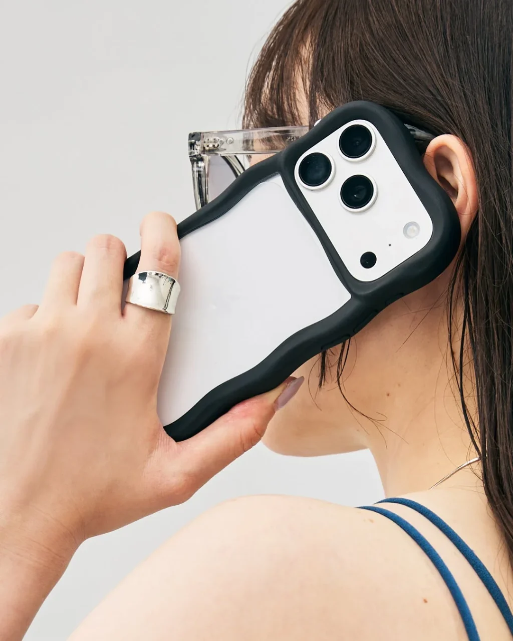 Flouのウェーブ形状ケースを装着したiPhoneを手に持つ利用シーン