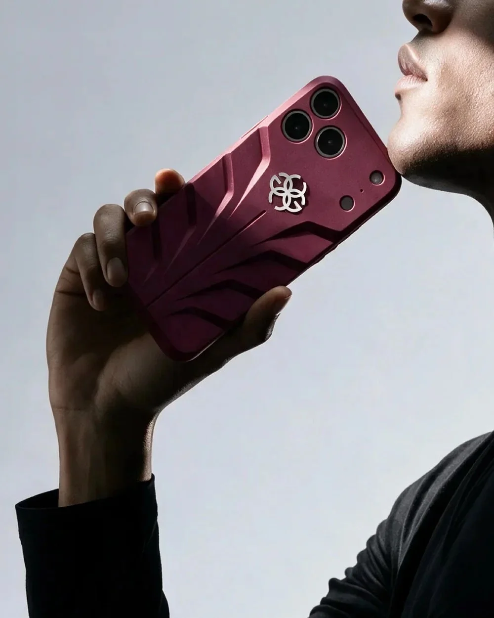 RACING SPORT MAGNETIC SHIELDの赤いiPhoneケースを手にした人物