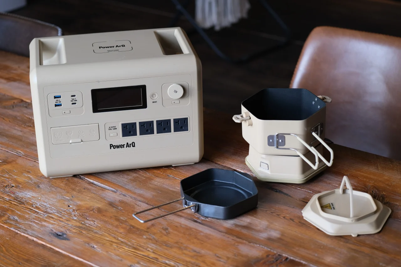 PowerArQのポータブル電源とDuoPotの鍋・フライパン・蓋が木製テーブルに置かれている