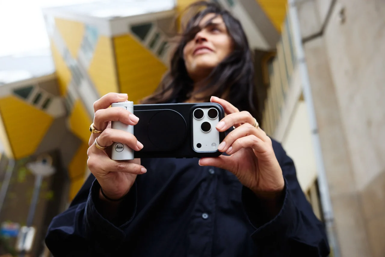 女性がLeica LUXグリップ シルバーとLeica LUXケースを装着したiPhoneを構えて撮影する様子
