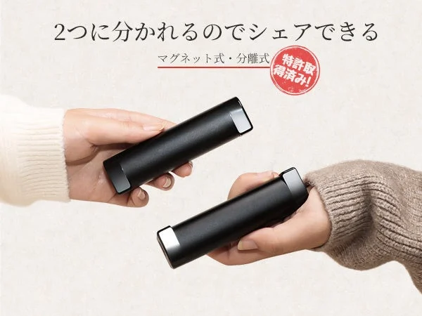 HAGOOGI充電式カイロOT-96Hのマグネット式分離構造を示す、2つに分かれた黒い円筒形本体を手に持つ画像
