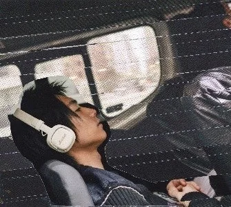車内で白いMilton A.N.C.を着けて目を閉じる人物